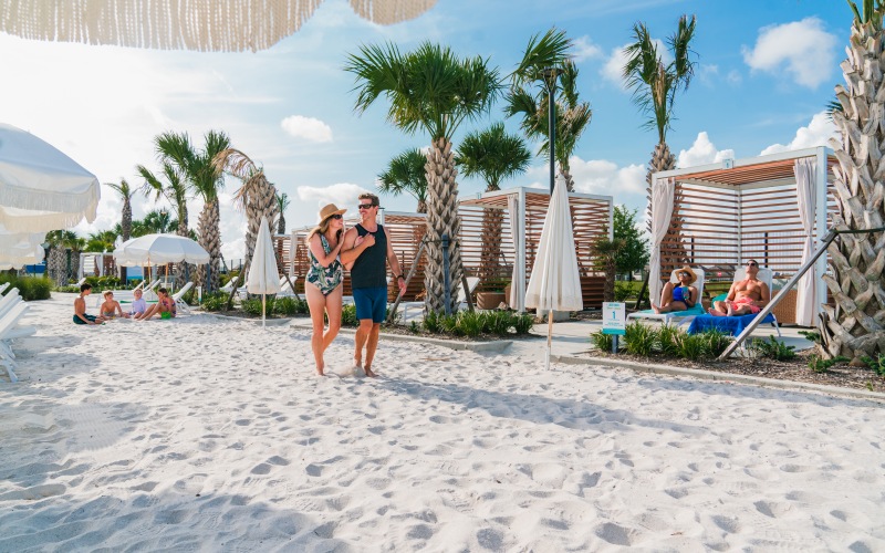 couple walking on the beach with palm trees